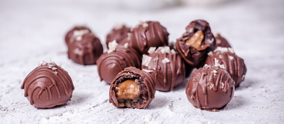 Chocolate Cake Balls mit Schokoladenglasur, Meersalz-Topping und flüssigem Karamellkern, einige angeschnitten