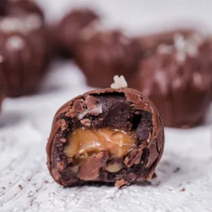 Chocolate Cake Balls mit Schokoladenglasur, Meersalz-Topping und flüssigem Karamellkern, einige angeschnitten