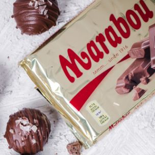 Chocolate Cake Balls mit Schokoladenglasur, Meersalz-Topping und flüssigem Karamellkern, daneben eine Marabou Vollmilch-Nuss Schokolade