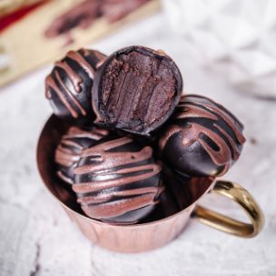 Chocolate Cake Balls mit Schokoladenglasur, Meersalz-Topping und flüssigem Karamellkern in einem Becher angerichtet